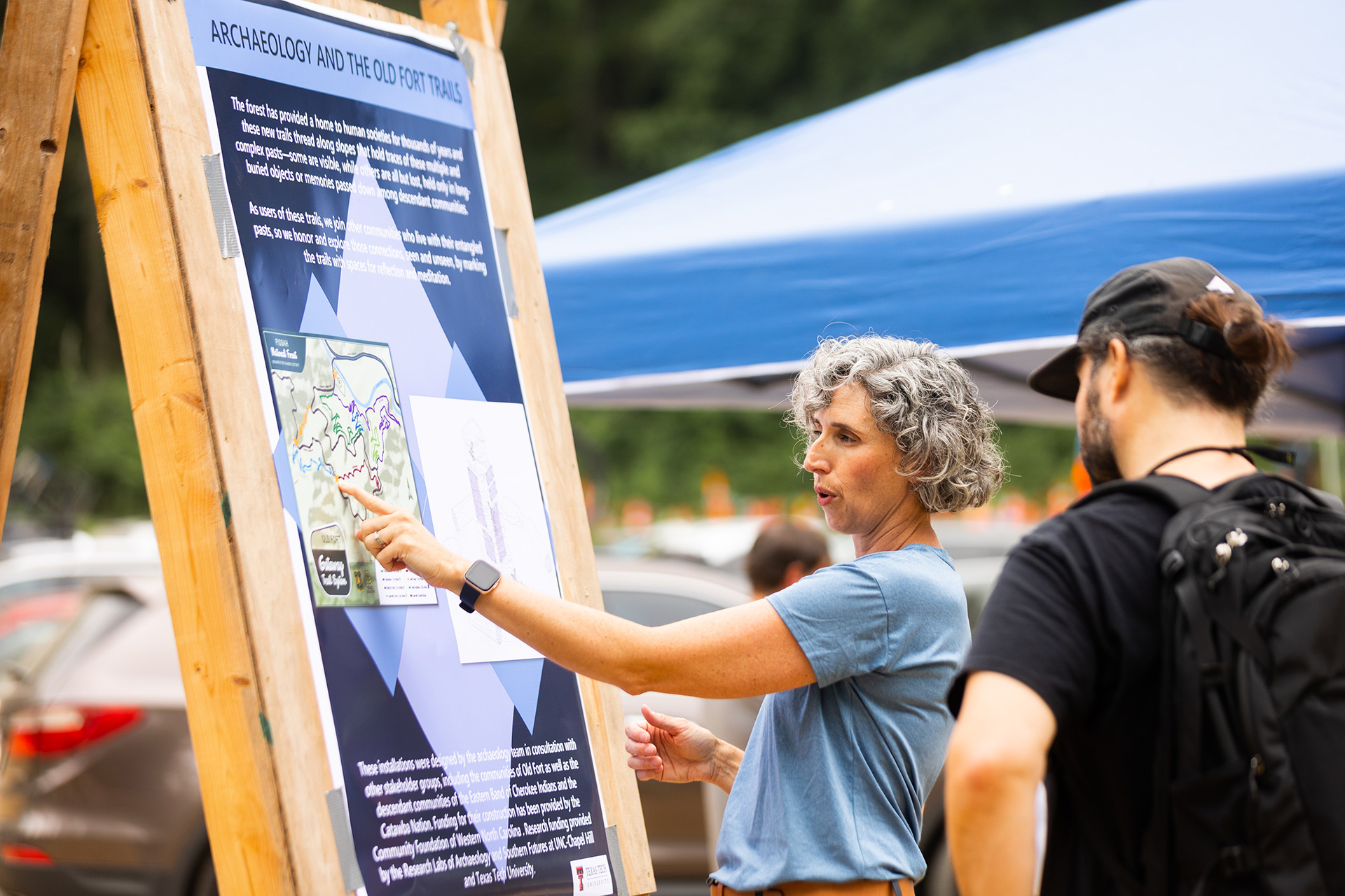 CONDENSED-Archaeology-sign-and-people-pointing Jennifer Gates-Foster, an archaeologist at UNC-Chapel Hill, shares some of Old Fort’s history at the June 2022 opening of the first six miles of trails. (Photograph by Darrell Cassell)
