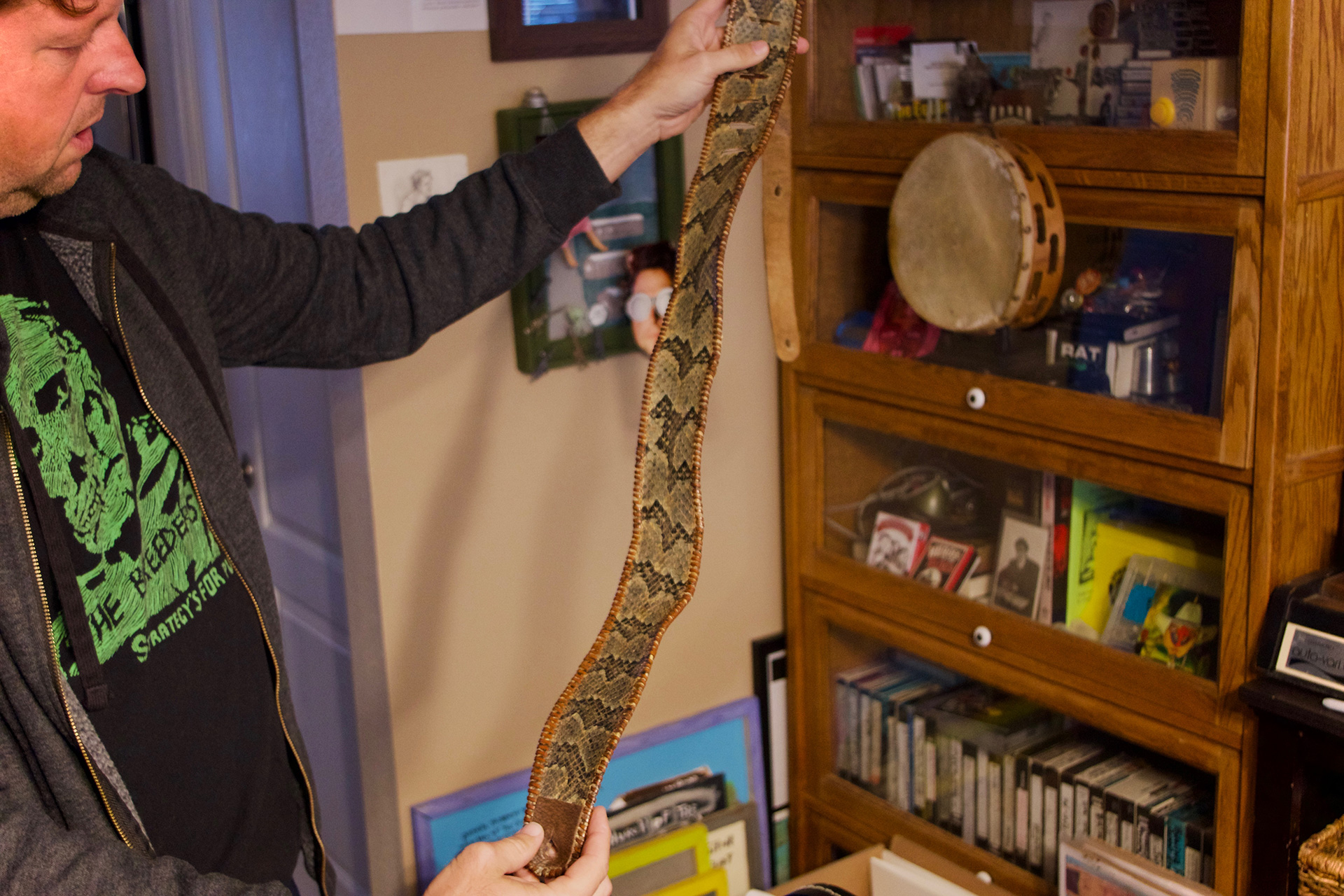 Abe with a guitar strap made from the skin of Old Lemonhead, a prized rattlesnake from the Coots family's church (photograph by Eli Bartlett)