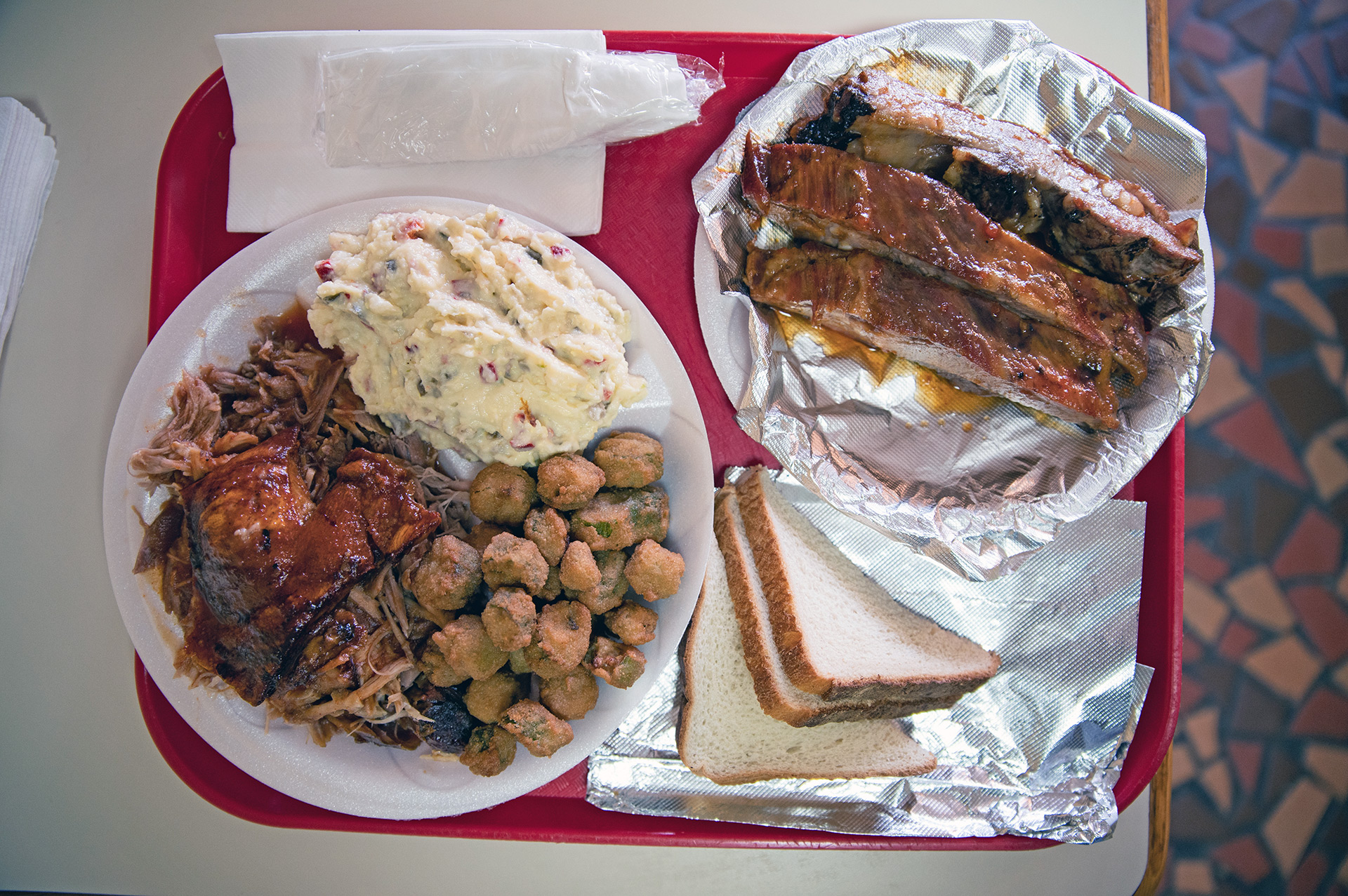 A prodigious portion of barbecued ribs, pork shoulder, potato salad and fried okra bends the plate at Lannie’s BBQ Spot.