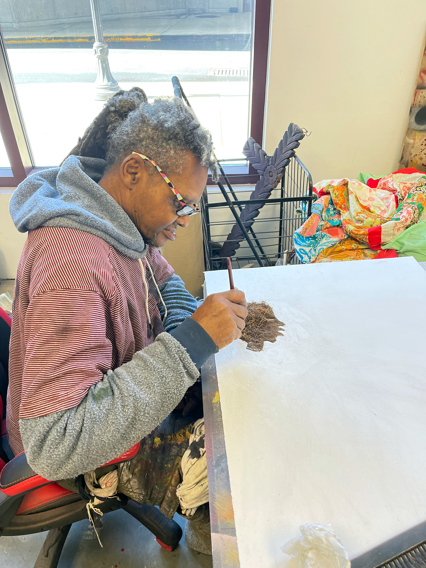 In his studio, Lonnie Holley arranges shreds of  tree roots (photograph by Matt Arnett).