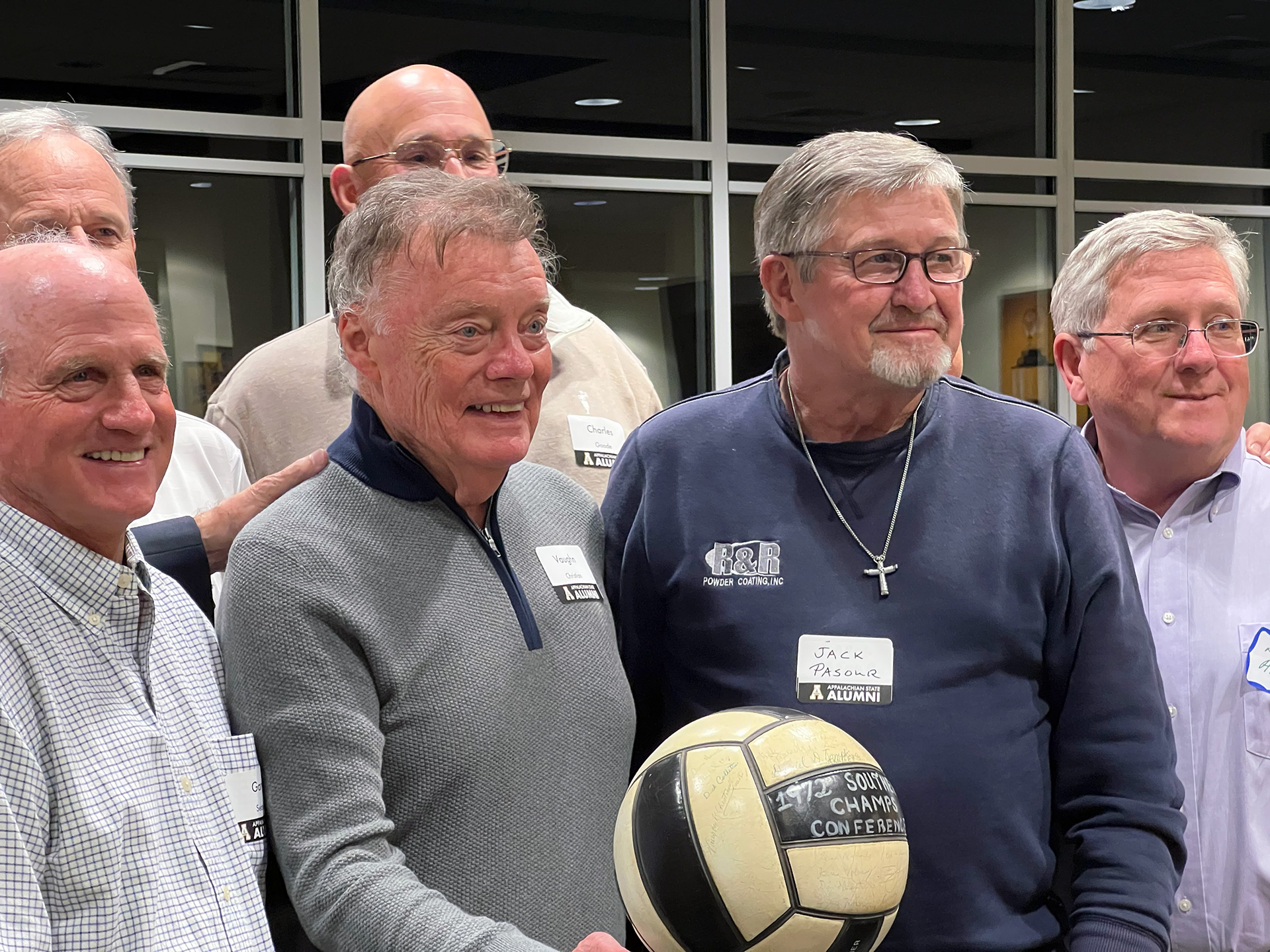 Vaughn Christian and his former players hold the game ball from when they won the Southern Conference championship in 1972 with a 1-0 victory over William & Mary (photograph by Ethan Joyce).