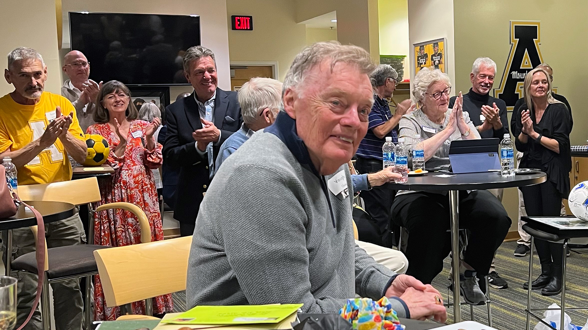 Coach Christian soaks in the applause at the surprise eightieth birthday party thrown by his former players and their families (photograph by Ethan Joyce).