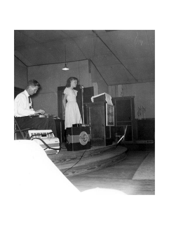 The author singing in church, accompanied by her father on steel guitar